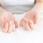 両手の爪を見る女性
